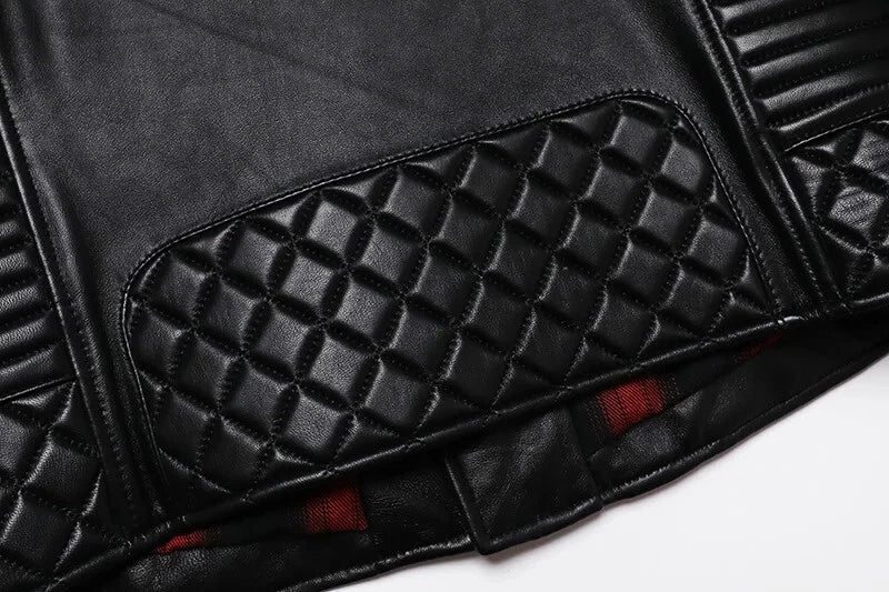 Close-up of a black leather jacket with quilted design and red accents on a white background