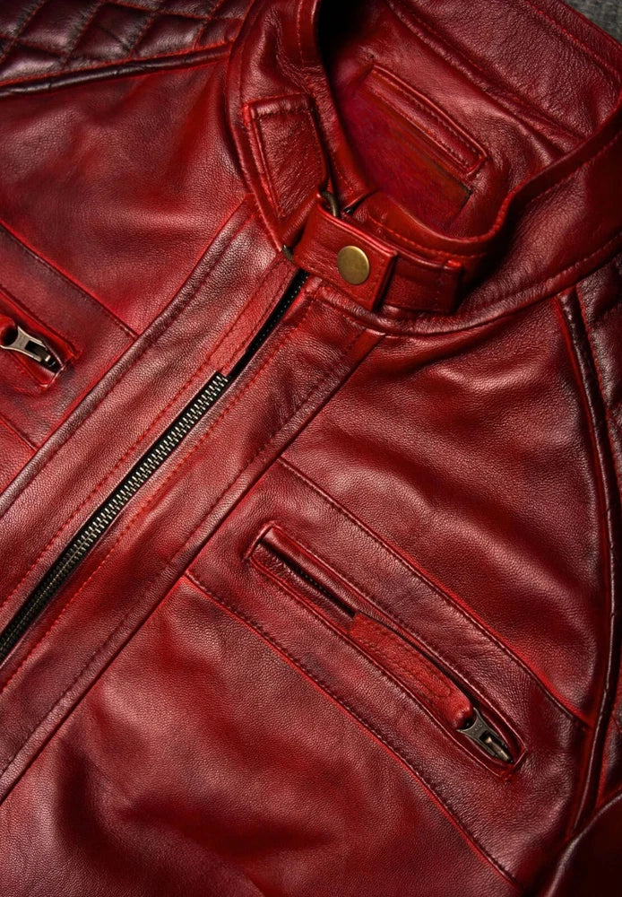 Close-up of a red leather jacket with zippers and buttons.