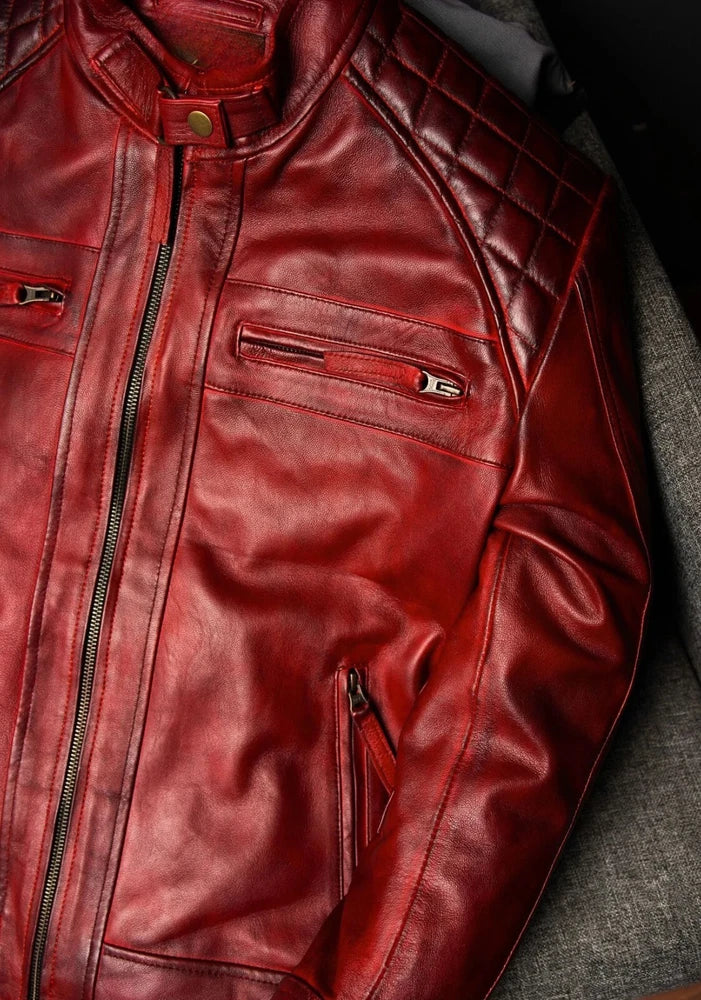 Close-up of a red leather jacket with zippers on a textured surface