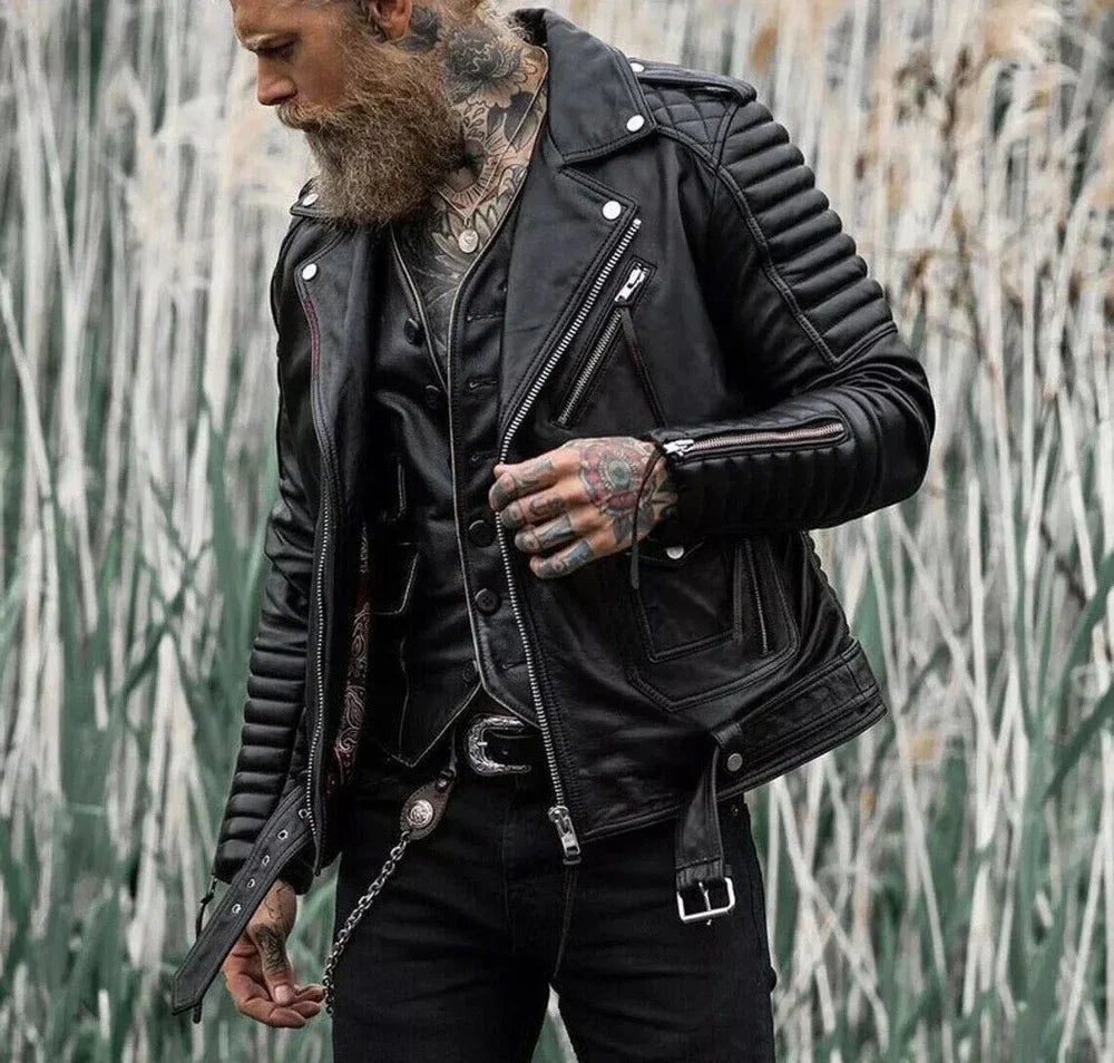Man wearing a black leather jacket with tattoos, standing against a natural background.