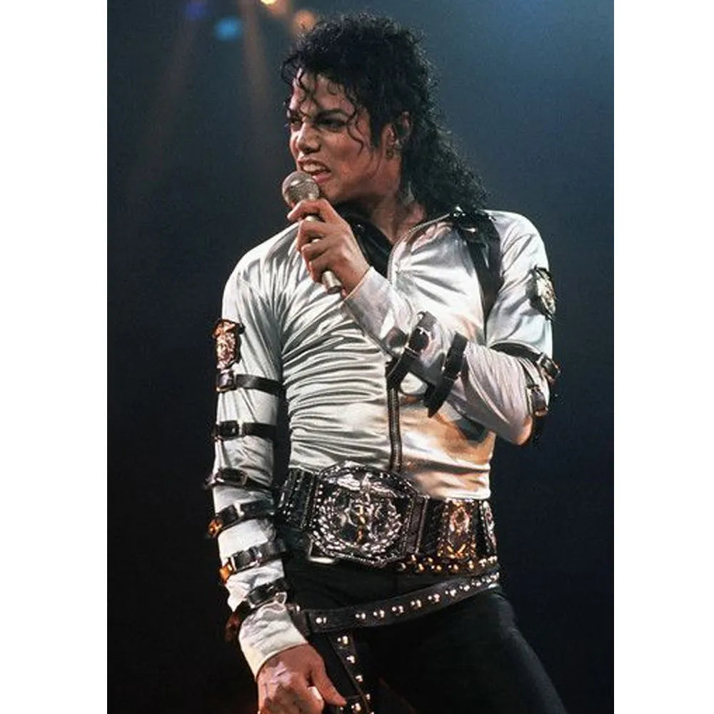 Person in a white outfit with black accents holding a microphone on a dark background