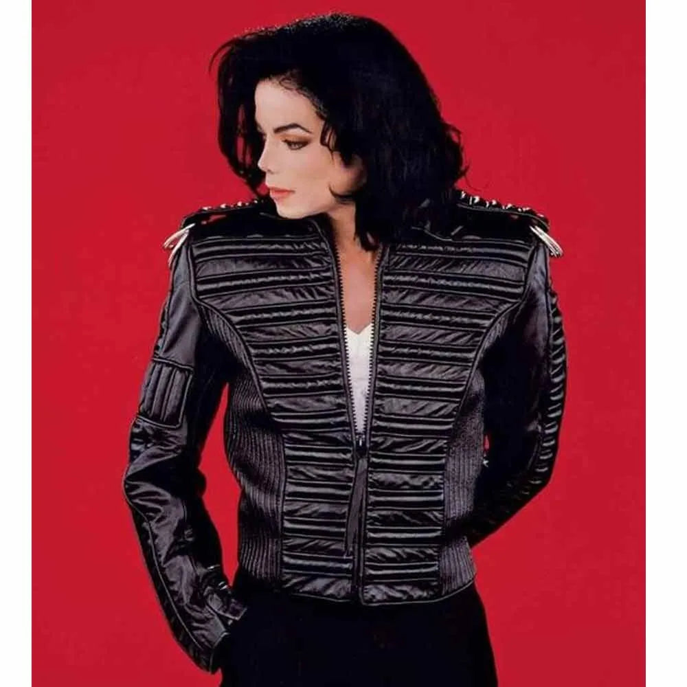 Person wearing a black quilted jacket with shoulder pads on a red background