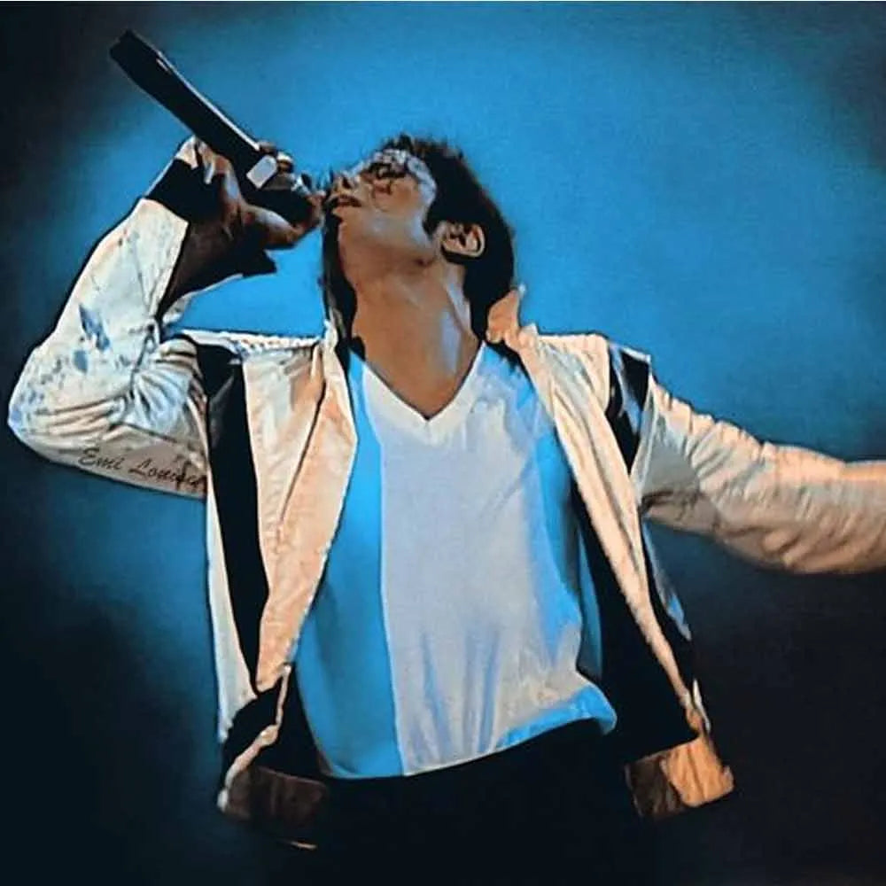 Person wearing a jacket with a blue and white pattern, holding a microphone against a blue background