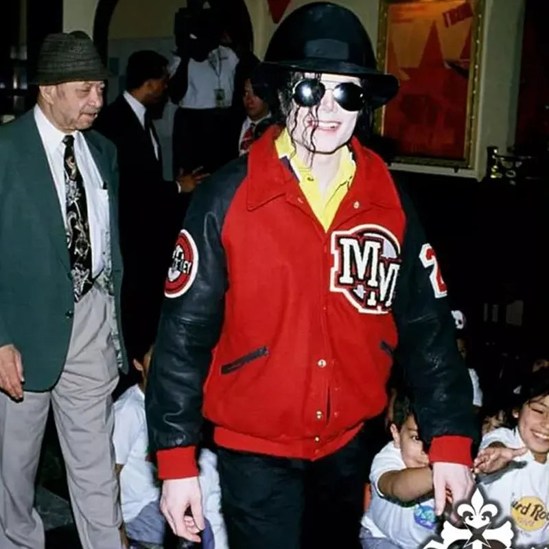 Person wearing a red and black jacket with 'Navy' logo, surrounded by people in a social setting.