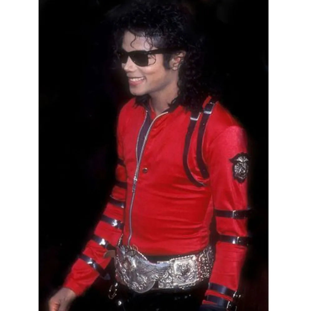 Person wearing a red jacket with black accents and a silver belt, against a dark background