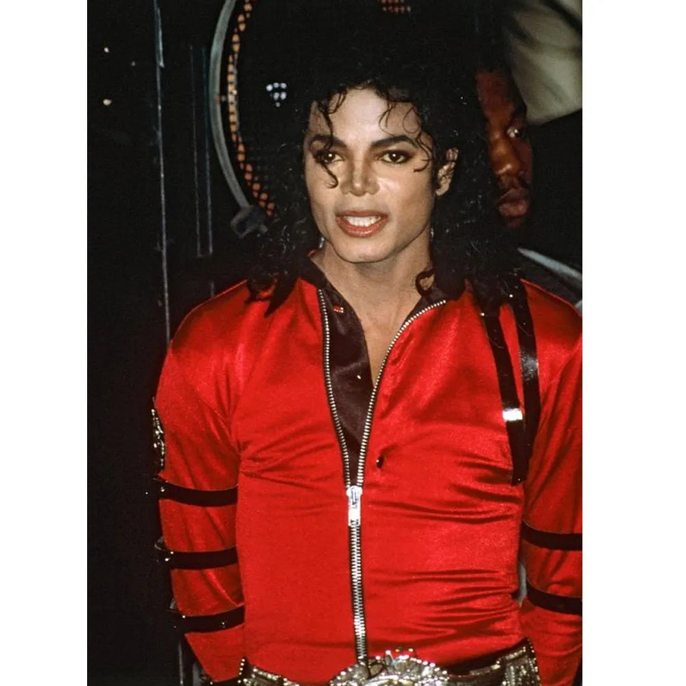 Person wearing a red outfit with black accents, standing against a dark background.