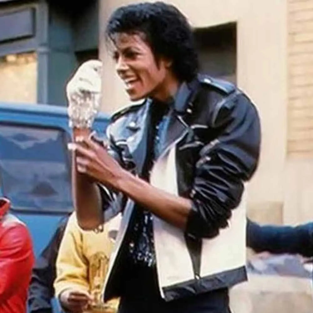 Person in a leather jacket holding an ice cream cone outdoors