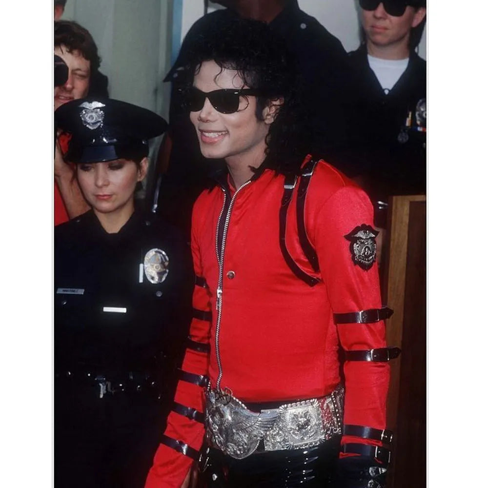 Person wearing a red jacket with black accents and sunglasses, standing in front of police officers.